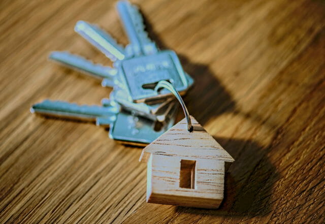 keys with a house keychain on a wooden table