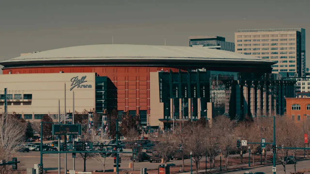 Ball Arena in Denver, Colorado, with surrounding city buildings visible.