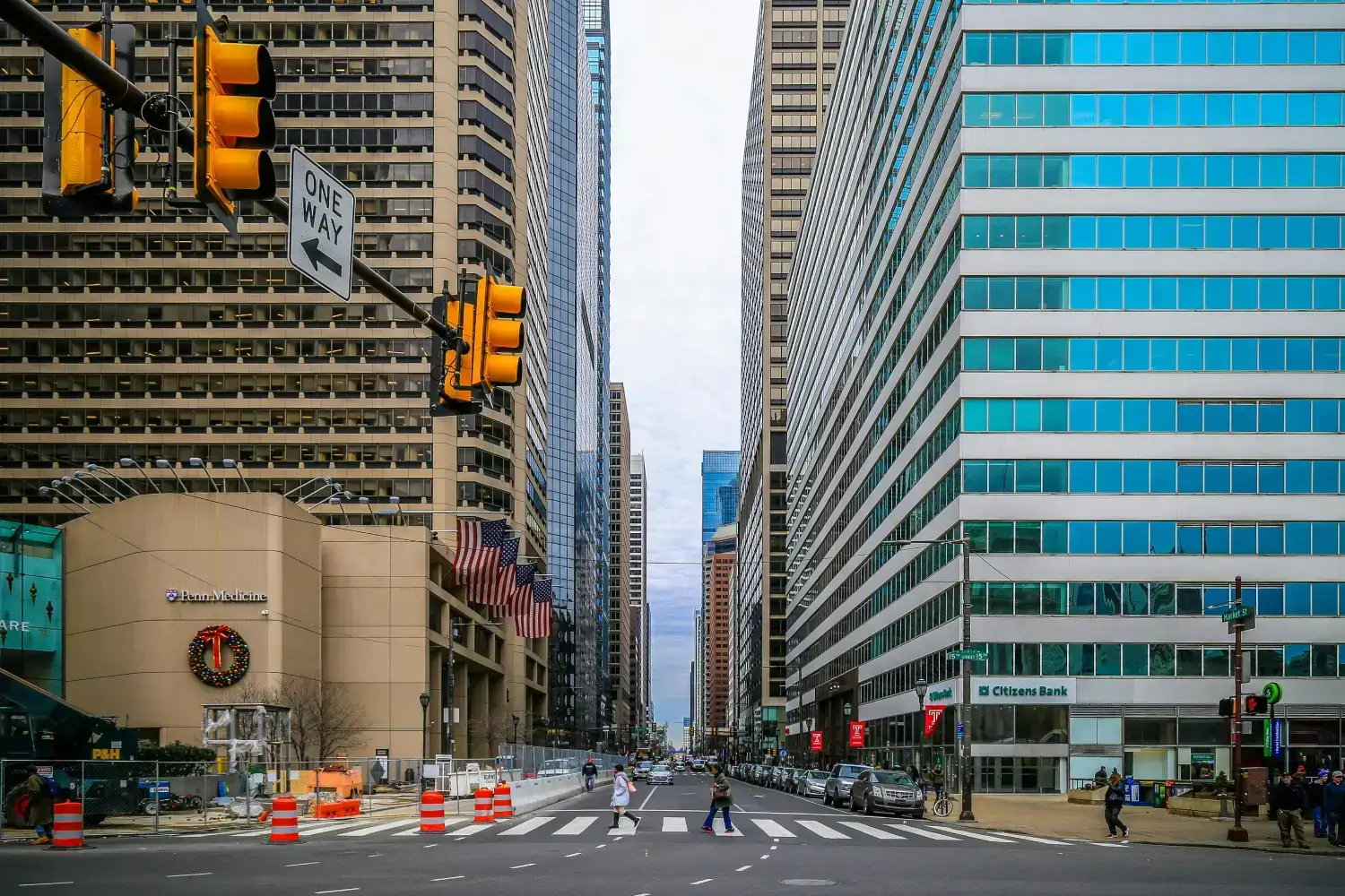 A busy street in downtown Philadelphia, Pennsylvania, with tall skyscrapers on both sides.