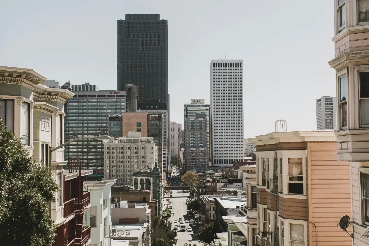 Downtown San Francisco view with high-rise buildings, classic architecture, and a steep urban street leading into the city center.