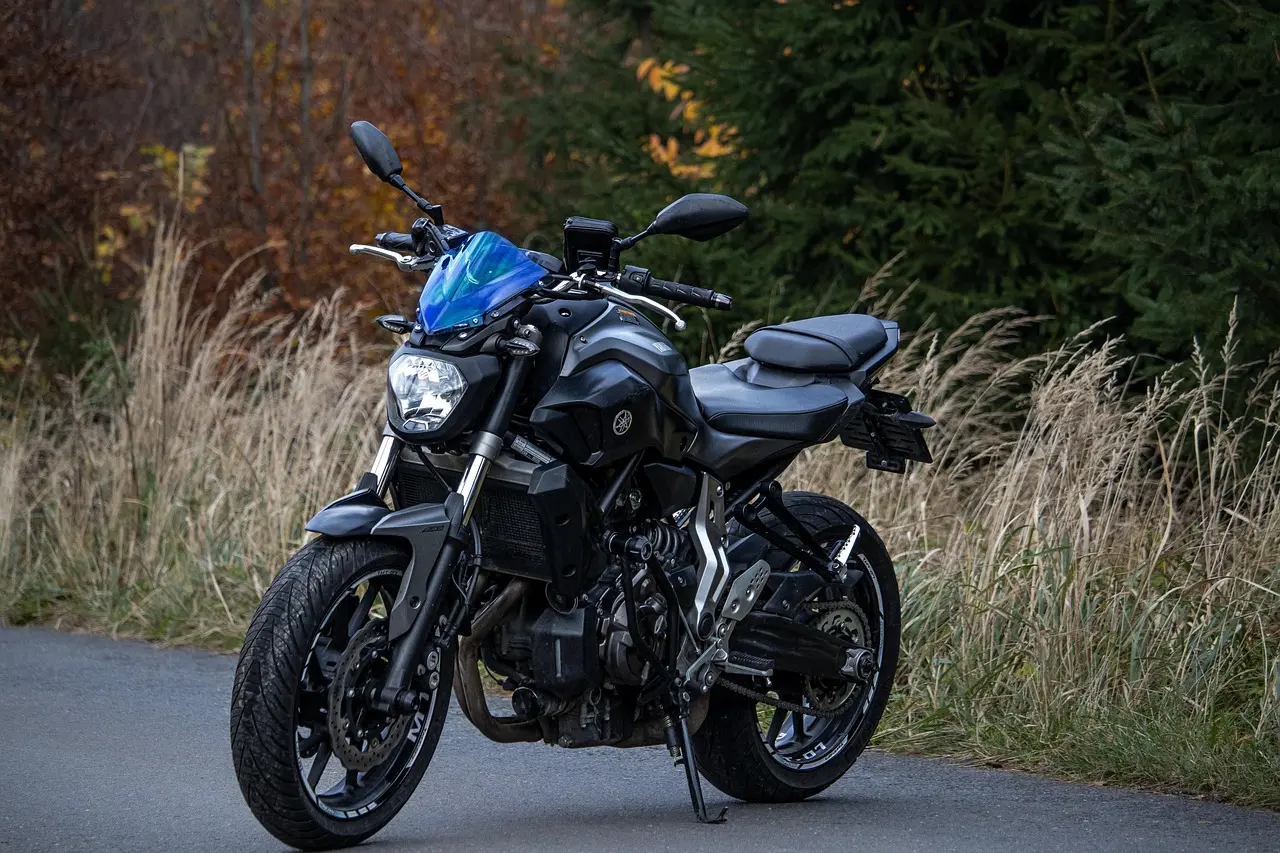 Light grey Yamaha MT-03 motorcycle with blue wheels on white background front-quarter view