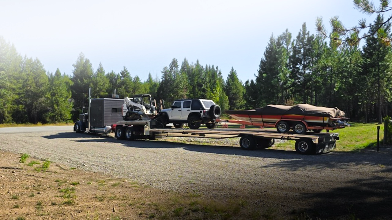 Flatbed truck transporting a Jeep, boat, and equipment – AutoStar Transport Express
