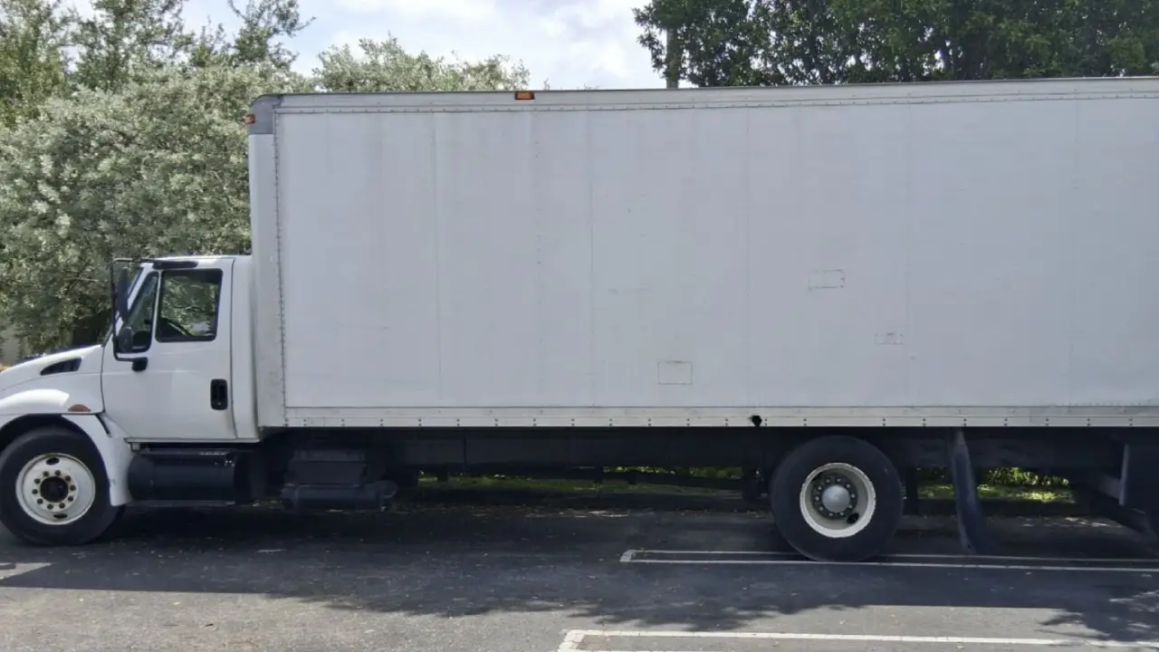 A white box truck from AutoStar Transport Express, parked in a lot on a sunny day.