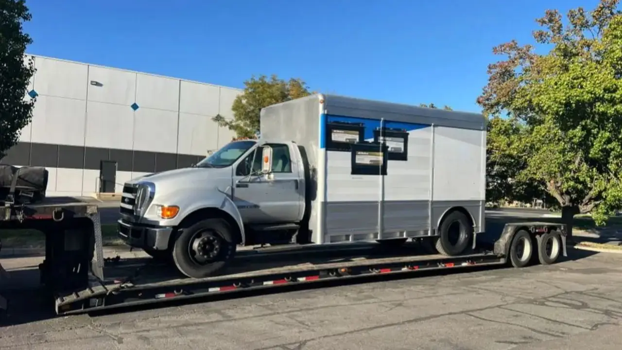 Oversized truck being transported on a flatbed trailer by AutoStar Transport Express