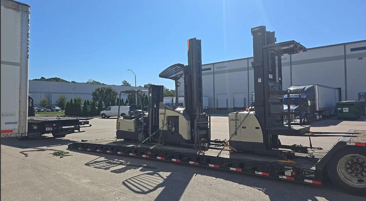 Crown forklifts chained on AutoStar Transport Express flatbed for reliable heavy equipment shippingk