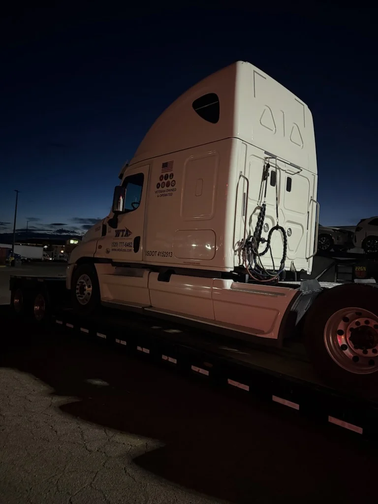 White sleeper semi-truck on AutoStar Transport Express flatbed for secure heavy-duty shipping