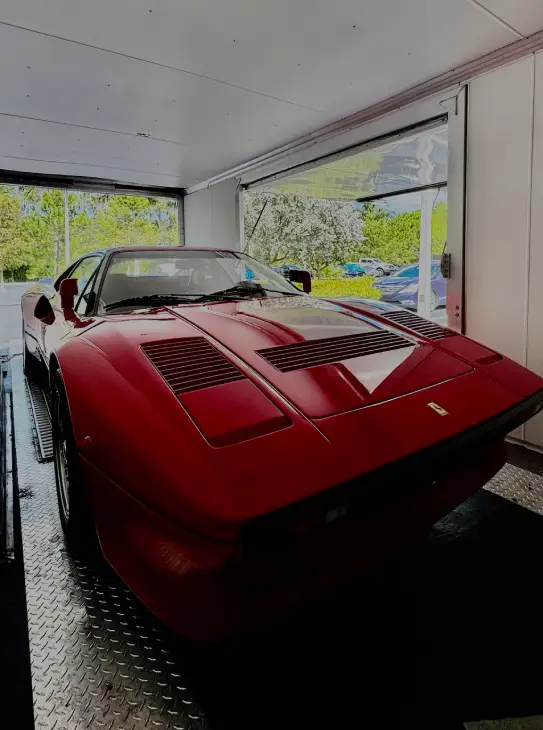 Red classic car securely loaded inside an enclosed auto transport trailer by AutoStar Transport Express.