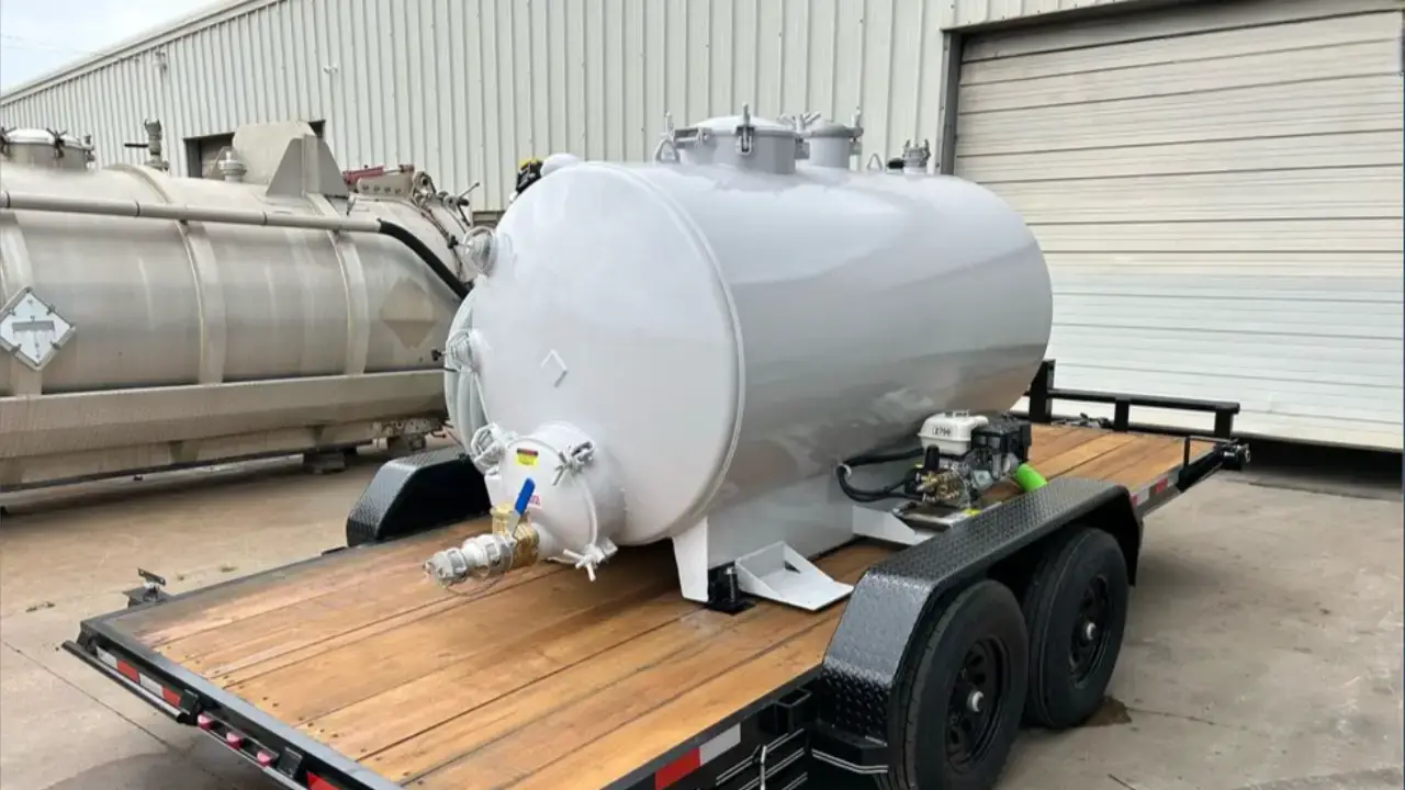 Industrial vacuum tank mounted on a flatbed trailer, ready for specialized equipment transport by AutoStar Transport Express.